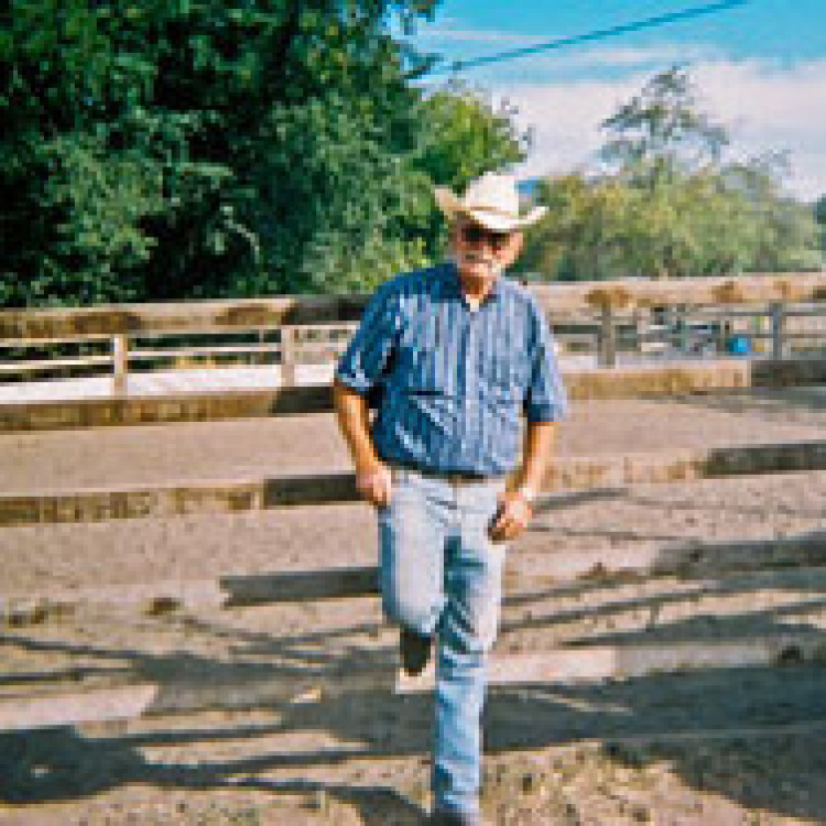 Merrill Gould (owner) leaning against a wood fence